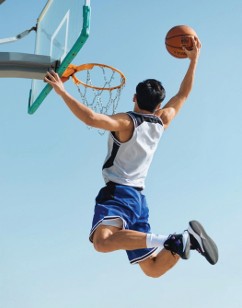 Outdoor basketball court with player dunking against clear sky
